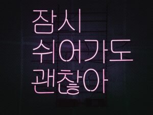 Leuchtendes Neon-Schild mit pinkem Schriftzug vor dunklem Hintergrund als modernes Design-Element