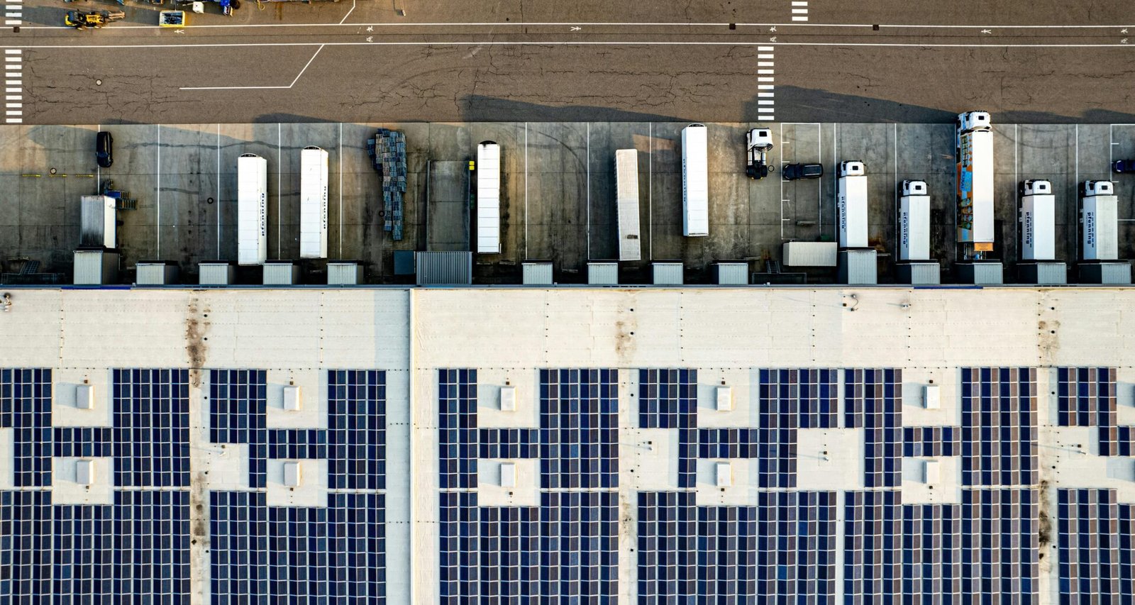 Luftaufnahme eines großen Parkplatzes mit vielen installierten Solarpanelen auf den Überdachungen der Stellplätze