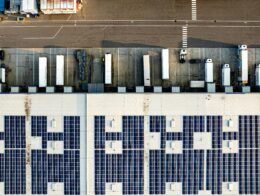 Luftaufnahme eines großen Parkplatzes mit vielen installierten Solarpanelen auf den Überdachungen der Stellplätze