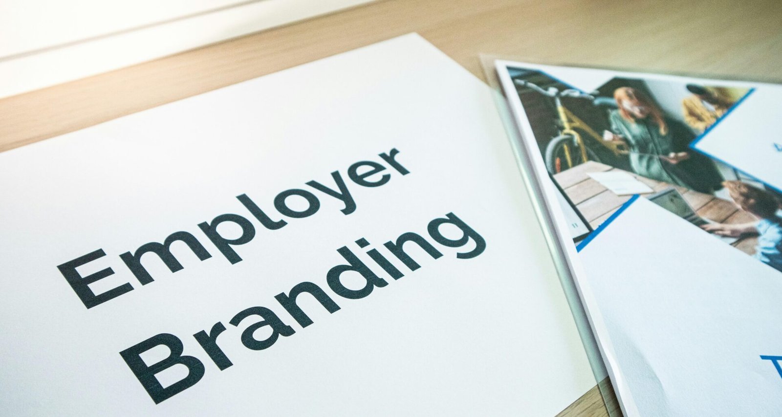 Eine Mitarbeiter Branding Broschüre liegt aufgeklappt auf einem Tisch und informiert über Unternehmenswerte.