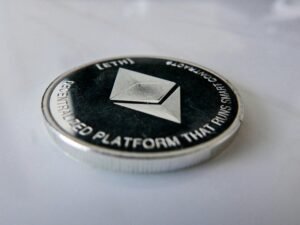 Nahaufnahme einer einzelnen Münze auf einem glatten Tisch, deutliche Details und Fokus auf die Kante der Münze