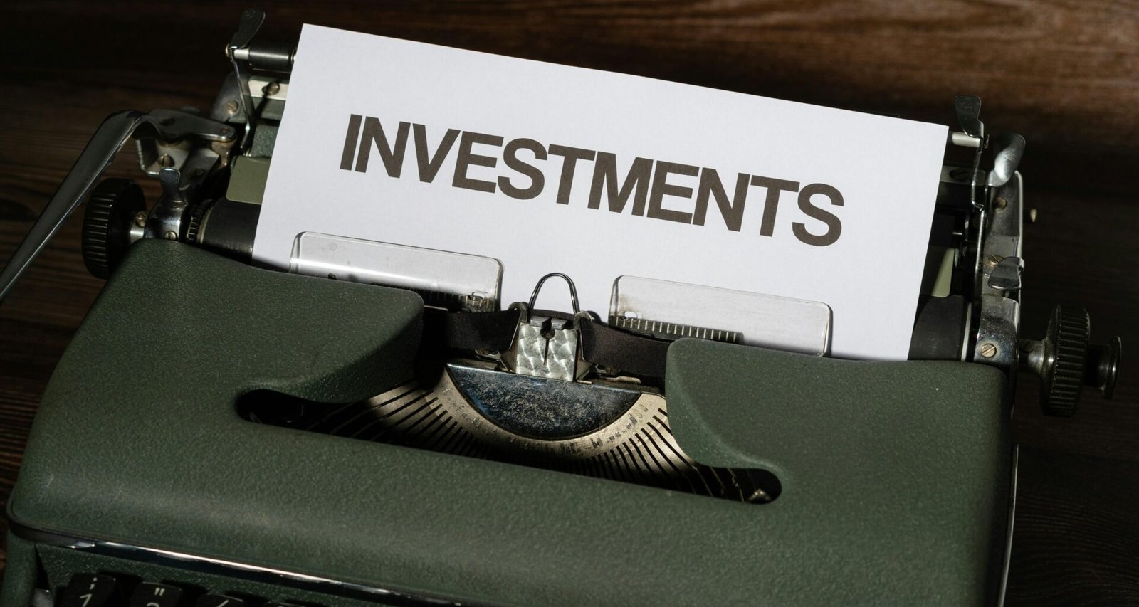 Schreibmaschine in Nahaufnahme mit Papier, auf dem Investments geschrieben steht. Symbol für finanzielle Themen und Investitionen.