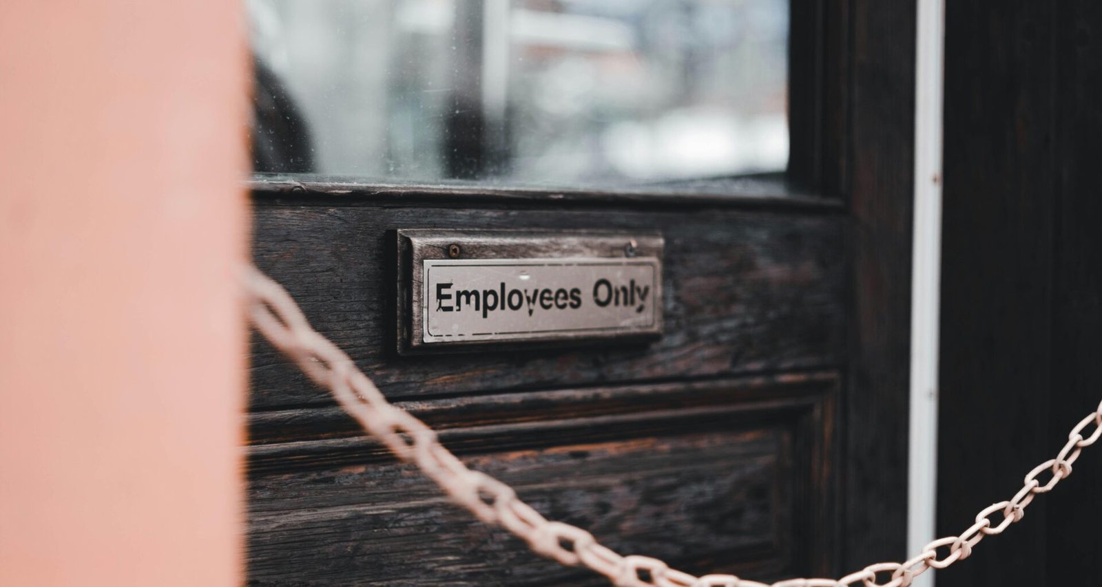 Nahaufnahme einer Tür mit einer Kette als Sicherung. Geeignet für Artikel über Sicherheit oder Zugangsschutz.