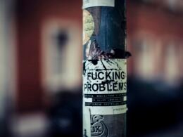 Detailansicht eines Stickers, der an einem Pfosten befestigt ist, aufgenommen im städtischen Bereich