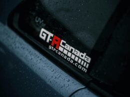 Nahaufnahme eines Autos mit zahlreichen Regentropfen auf der Karosserie, fotografiert bei feuchtem Wetter