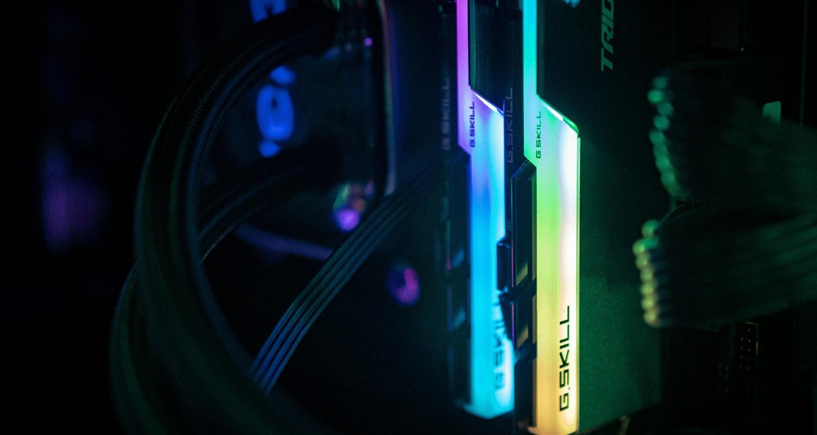 Nahaufnahme eines Computers mit zahlreichen Kabeln in einem dunklen Raum, Technik und Netzwerk-Hardware im Detail
