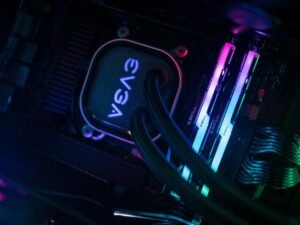 Detailansicht eines Computers und mehrerer Kabel auf einem Schreibtisch in einem dunklen Raum