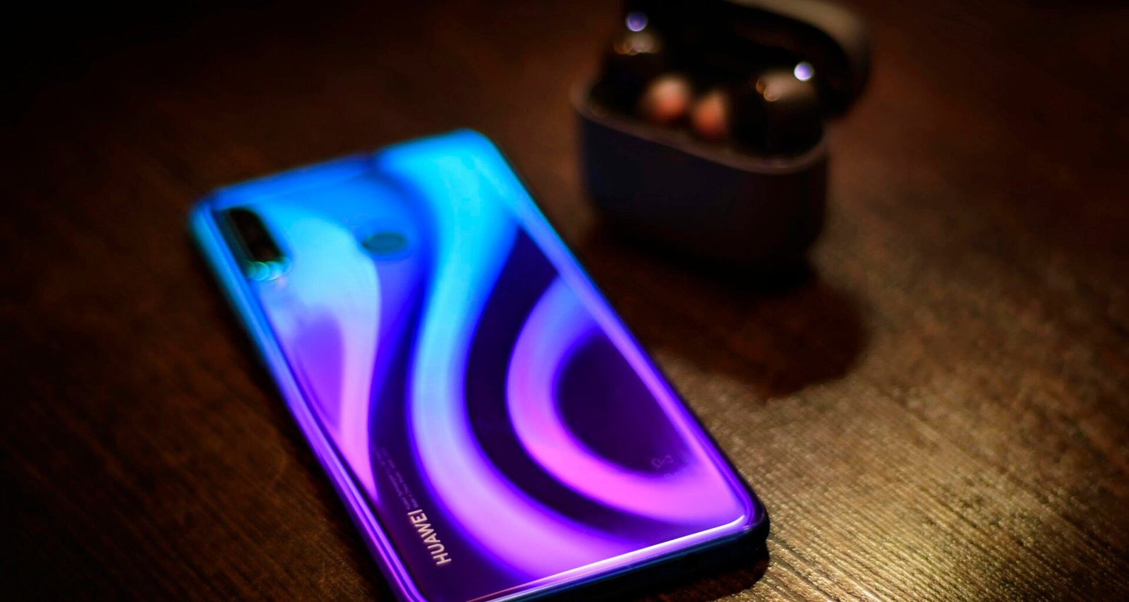 Detailansicht eines Smartphones, das auf einem Holztisch liegt, geeignet für Themen rund um Mobile, Technik und Kommunikation