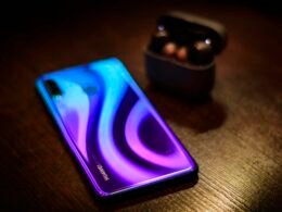 Detailansicht eines Smartphones, das auf einem Holztisch liegt, geeignet für Themen rund um Mobile, Technik und Kommunikation