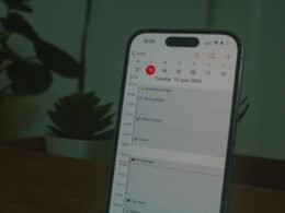 Ein Smartphone liegt auf einem Holztisch, aufgenommen in Nahaufnahme, Fokus auf das Gerät und seine Details.