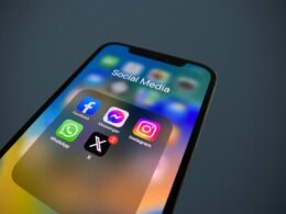 Nahaufnahme eines Smartphones mit mehreren Social-Media-Icons auf dem Bildschirm, symbolisch für digitale Vernetzung