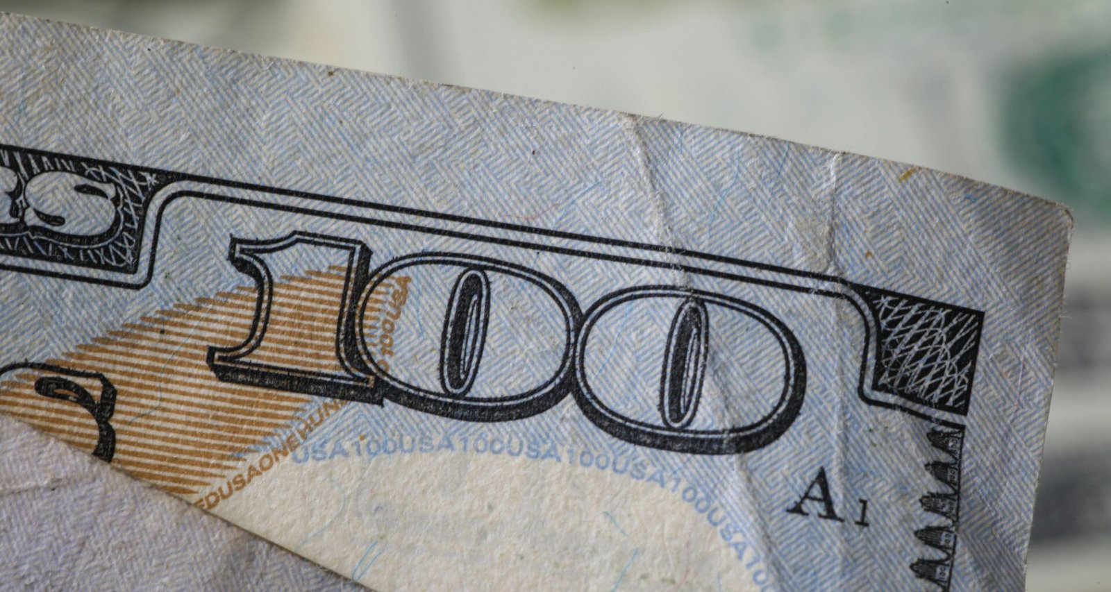 Nahaufnahme eines US-Hundert-Dollar-Scheins mit sichtbaren Details und Muster der Banknote