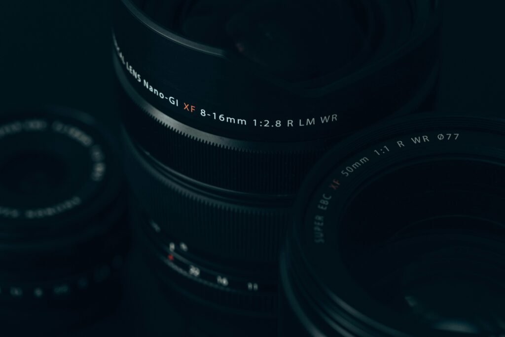 Nahaufnahme eines modernen Kameraobjektivs mit sichtbaren Linsen und Reflexionen, Fokus auf technische Details