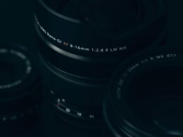 Nahaufnahme eines modernen Kameraobjektivs mit sichtbaren Linsen und Reflexionen, Fokus auf technische Details