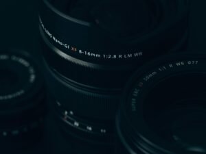 Nahaufnahme eines modernen Kameraobjektivs mit sichtbaren Linsen und Reflexionen, Fokus auf technische Details