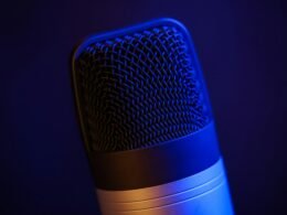 Detailaufnahme eines Mikrofons in einem schwach beleuchteten Raum, geeignet für Themen rund um Audio oder Technik