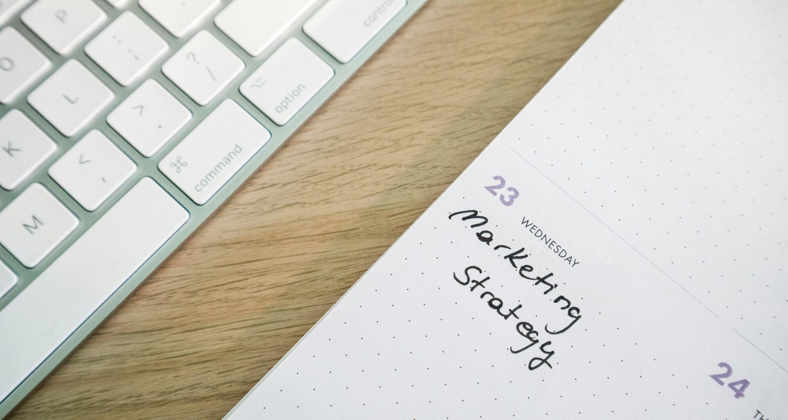 Nahaufnahme eines Notizblocks auf einem Schreibtisch neben einer Tastatur, ideal für Themen zu Bürotechnik und Organisation