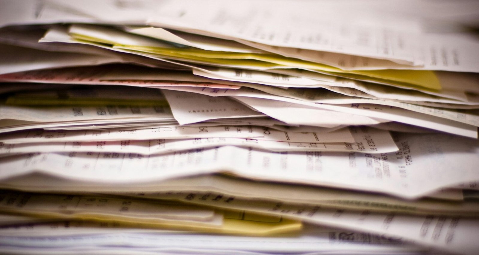 Nahaufnahme eines gestapelten Papierstapels, geeignet als Symbolbild für Dokumentenmanagement und Organisation