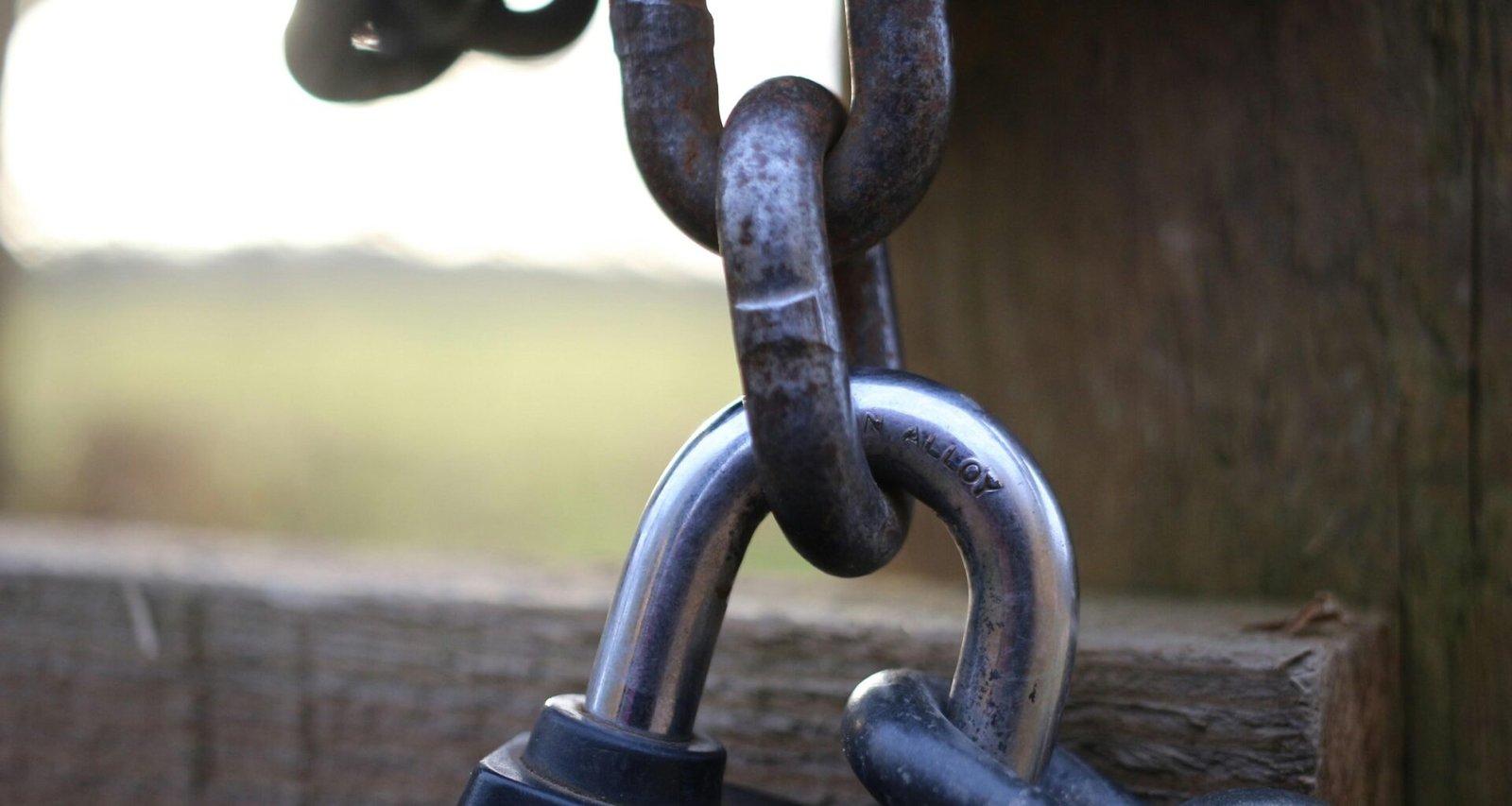 Nahaufnahme eines Vorhängeschlosses an einem alten Holzzaun, als Symbol für Datenschutz und Sicherheit im Internet.