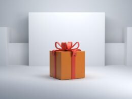 Orange Geschenkbox mit roter Schleife, detailiert aufgenommen auf hellem Hintergrund, als Symbolbild für Geschenke und Anlässe