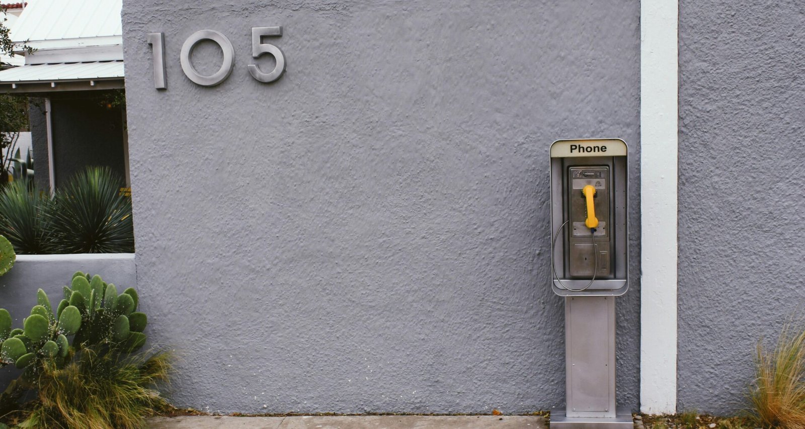 Eine einzelne Parkuhr steht am Rand eines Gehwegs in einer Stadt, aufgenommen bei Tageslicht.
