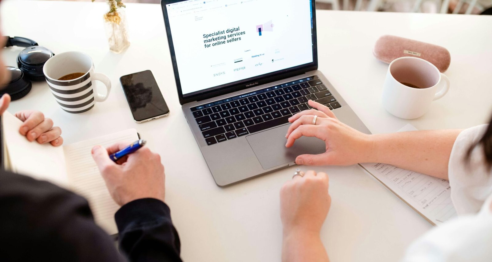 Person arbeitet konzentriert an einem Laptop an einem Tisch; moderne Technik im Arbeitsumfeld.