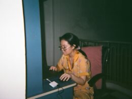 Eine Person sitzt an einem Schreibtisch und arbeitet konzentriert am Computer in einem modernen Büro.