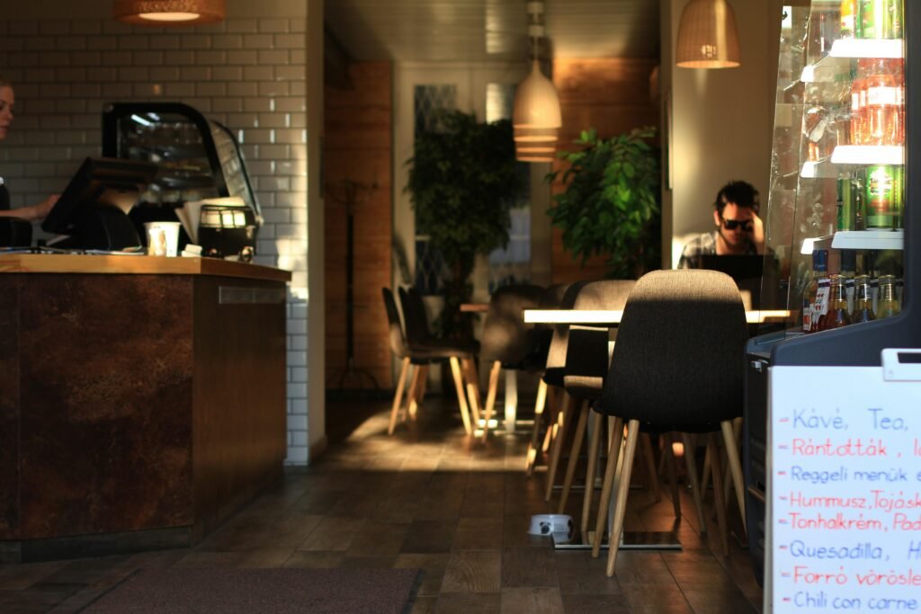 Eine Person sitzt entspannt an einem Tisch in einem Restaurant und arbeitet oder genießt eine Pause.