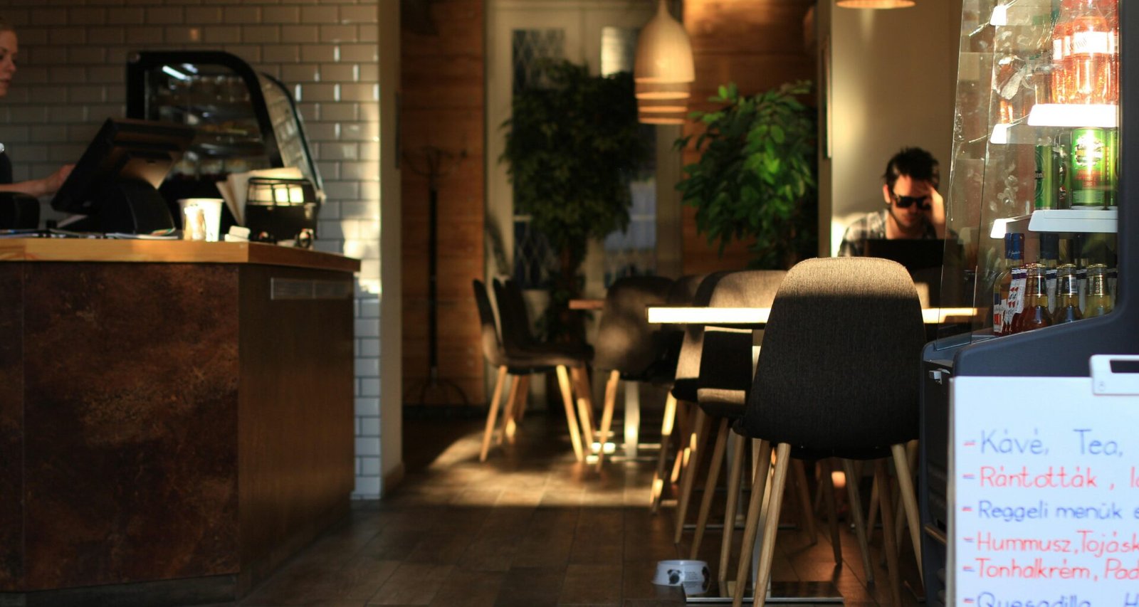 Eine Person sitzt entspannt an einem Tisch in einem Restaurant und arbeitet oder genießt eine Pause.