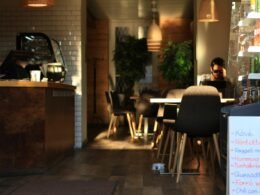 Eine Person sitzt entspannt an einem Tisch in einem Restaurant und arbeitet oder genießt eine Pause.