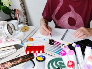 Person schreibt mit einem Stift auf ein Blatt Papier, Fokus auf der Hand beim Schreiben, Thema Arbeit oder Planung.