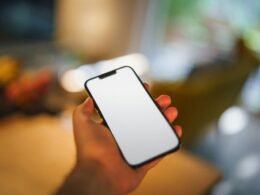 Eine Person hält ein modernes Smartphone in der Hand, Fokus auf das Mobilgerät, geeignet für digitale Themen