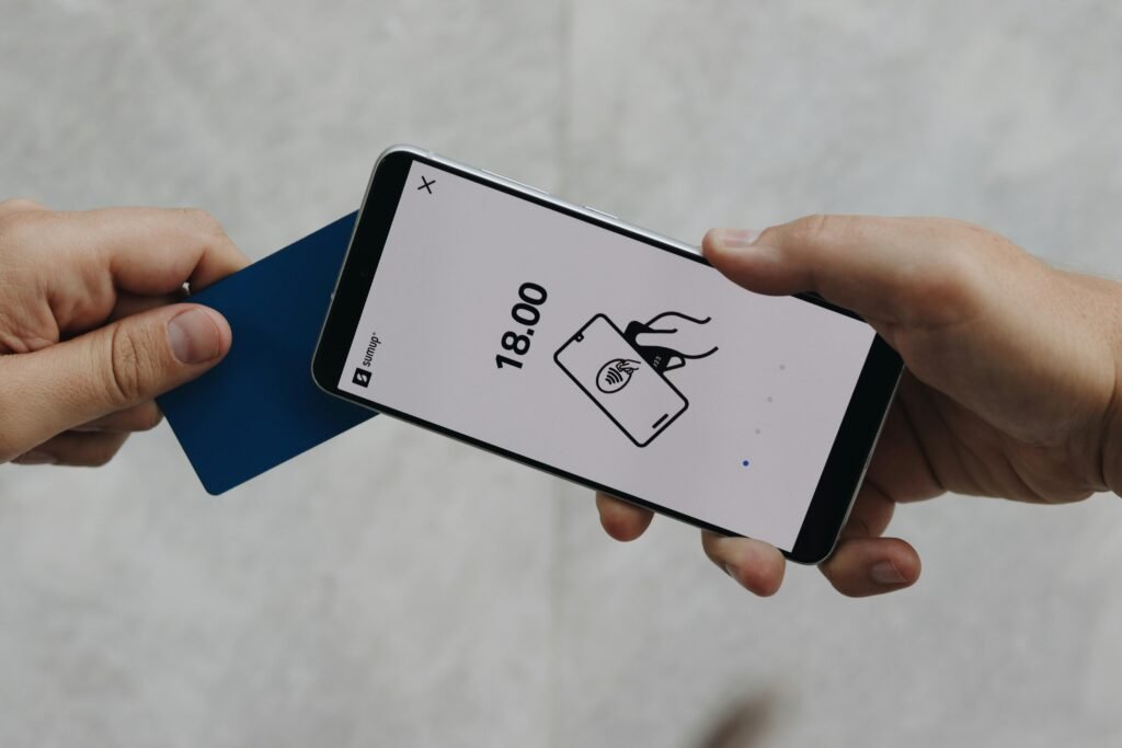 Nahaufnahme einer Person, die ein Smartphone in der Hand hält und damit interagiert, Fokus auf das Mobilgerät