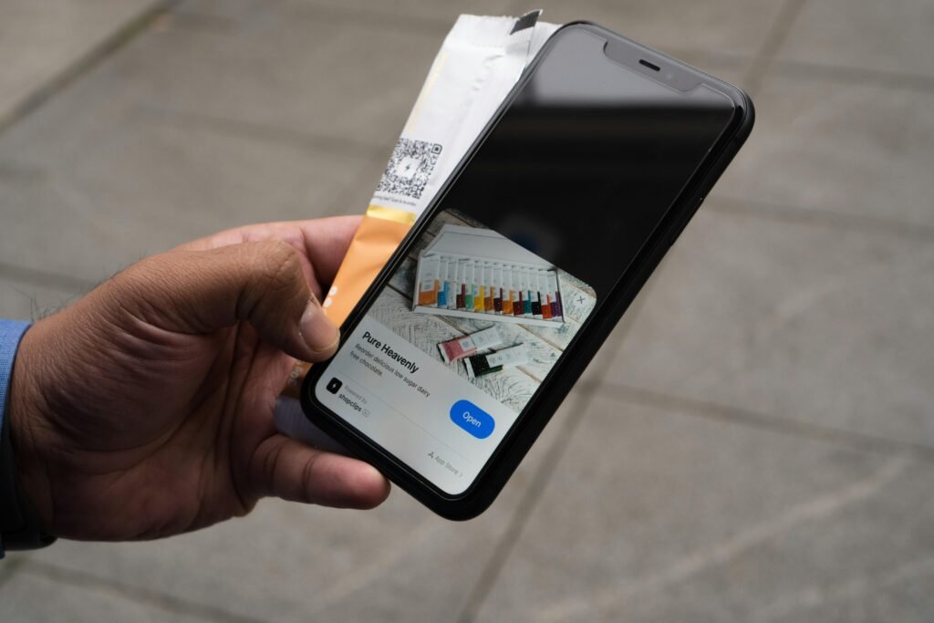 Person hält ein iPhone und eine Kreditkarte in der Hand, bereit für eine mobile Online-Zahlung