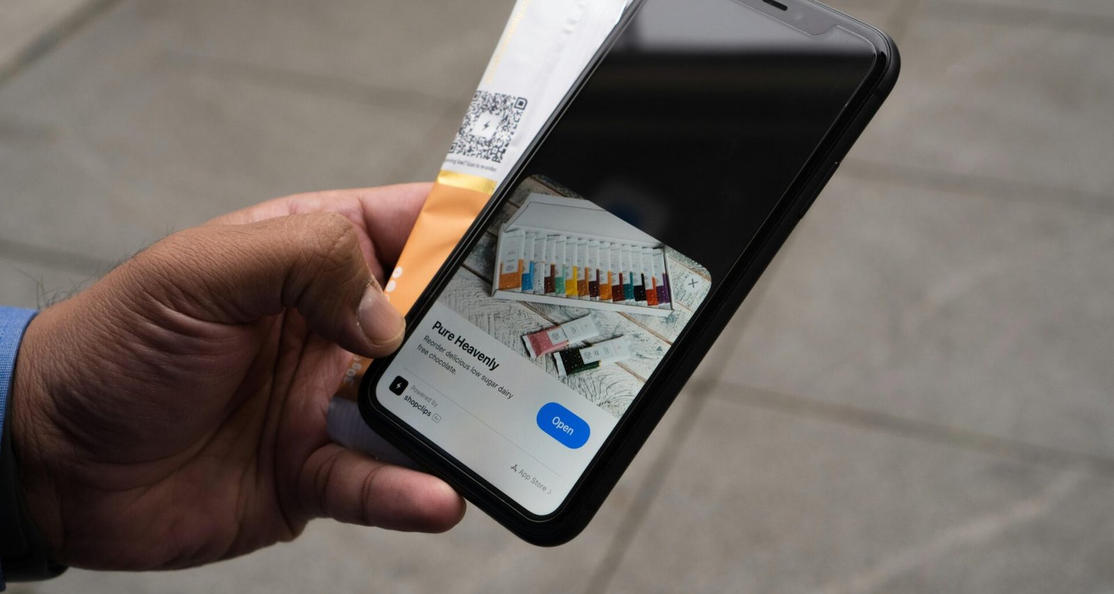 Person hält ein iPhone und eine Kreditkarte in der Hand, bereit für eine mobile Online-Zahlung