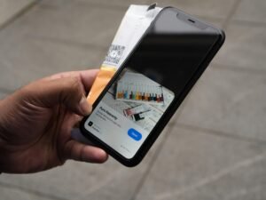 Person hält ein iPhone und eine Kreditkarte in der Hand, bereit für eine mobile Online-Zahlung