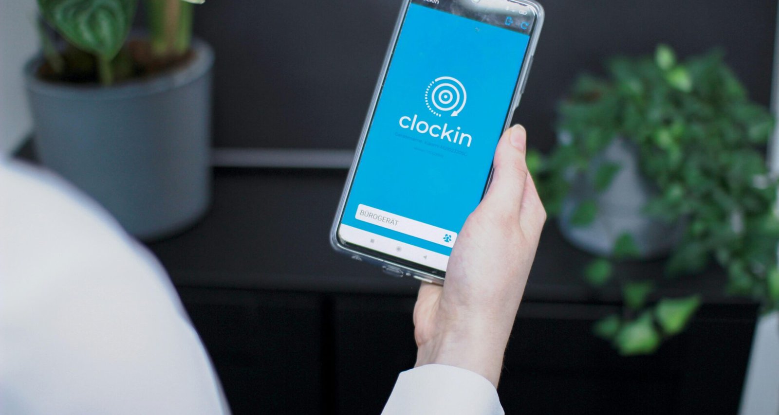 Eine Person hält ein Smartphone in der Hand, Fokus auf das Gerät und die Bedienung im modernen Alltag.