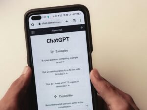 Eine Person hält ein Smartphone mit geöffneter Chat-App in der Hand und kommuniziert digital.