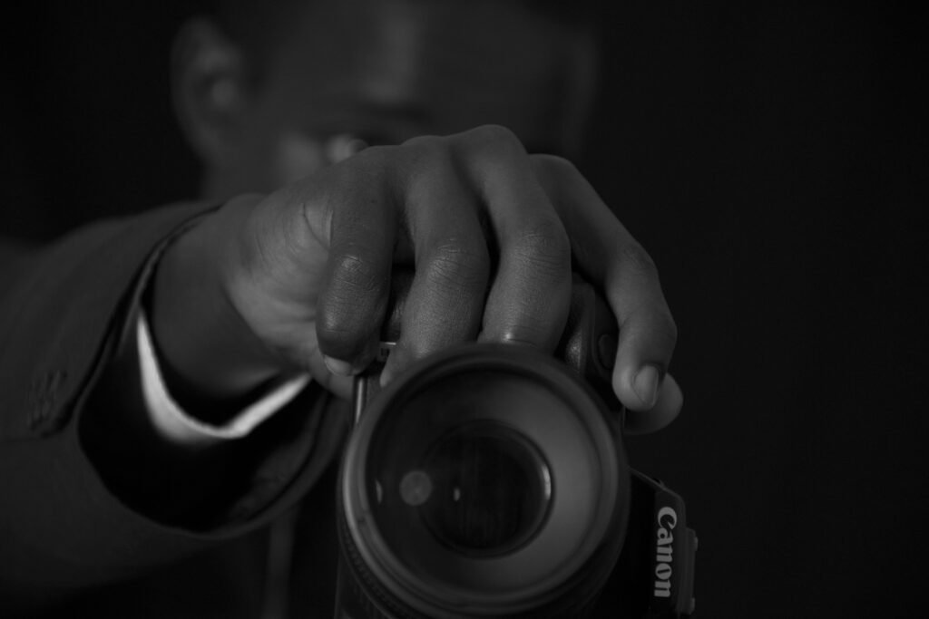 Eine Person hält eine Kamera und bereitet die Aufnahme vor, ideal als Symbolbild für Technik, Fotografie und Online-Marketing.