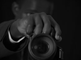 Eine Person hält eine Kamera und bereitet die Aufnahme vor, ideal als Symbolbild für Technik, Fotografie und Online-Marketing.