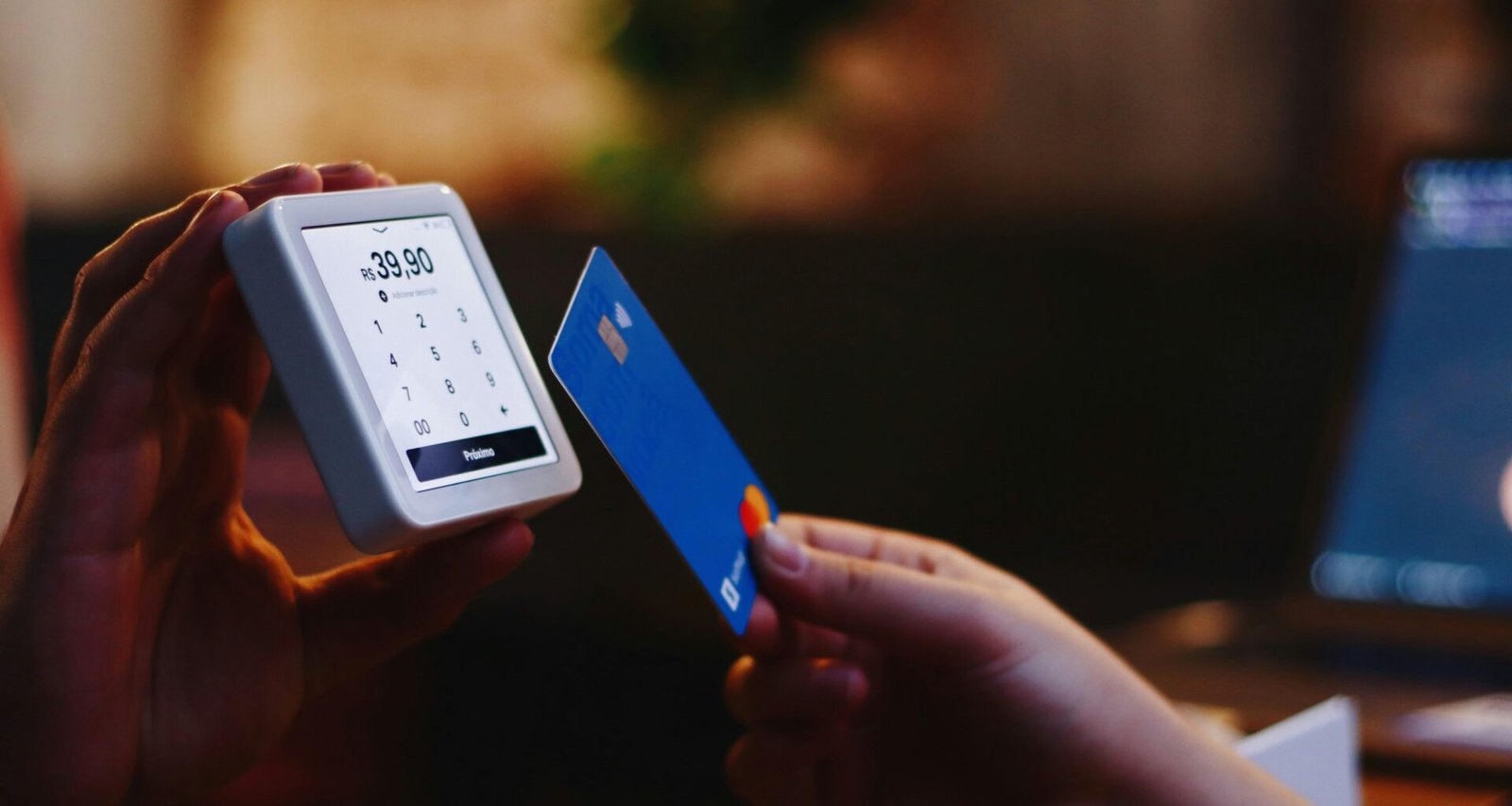 Eine Person hält eine Kreditkarte und ein Smartphone, bereit für eine Online-Transaktion oder mobiles Bezahlen