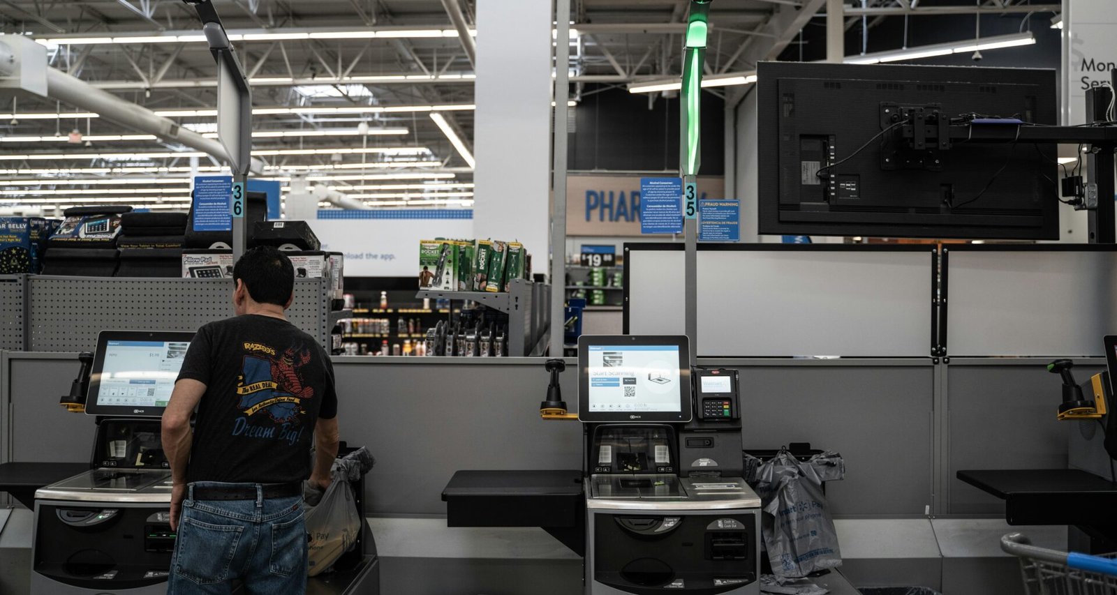 Eine Person steht in einem Raum mit mehreren Computern und technischer Ausrüstung, typische IT-Arbeitsumgebung.