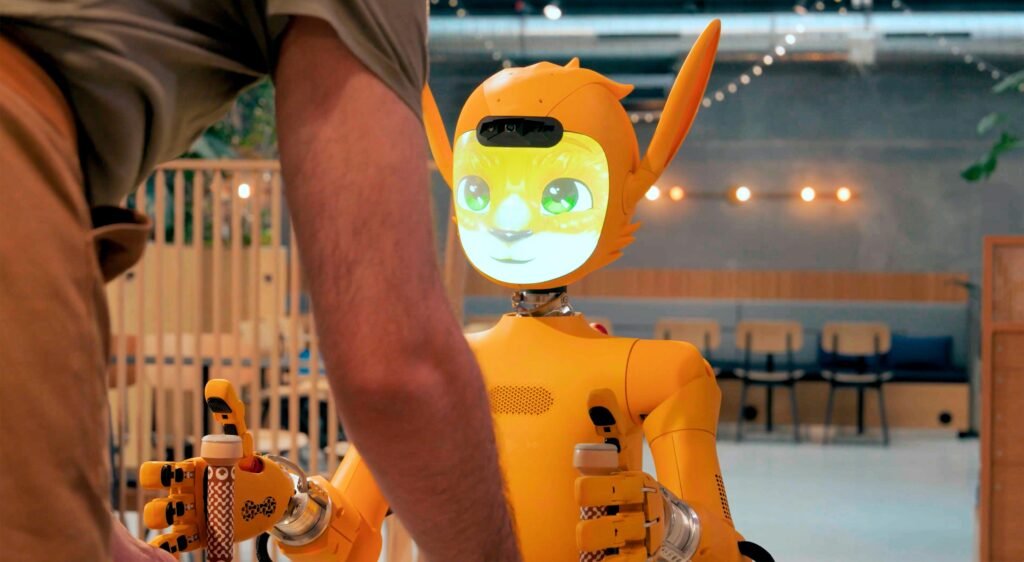 Eine Person steht einem orangefarbenen Roboter gegenüber und interagiert mit ihm in einer modernen Umgebung.