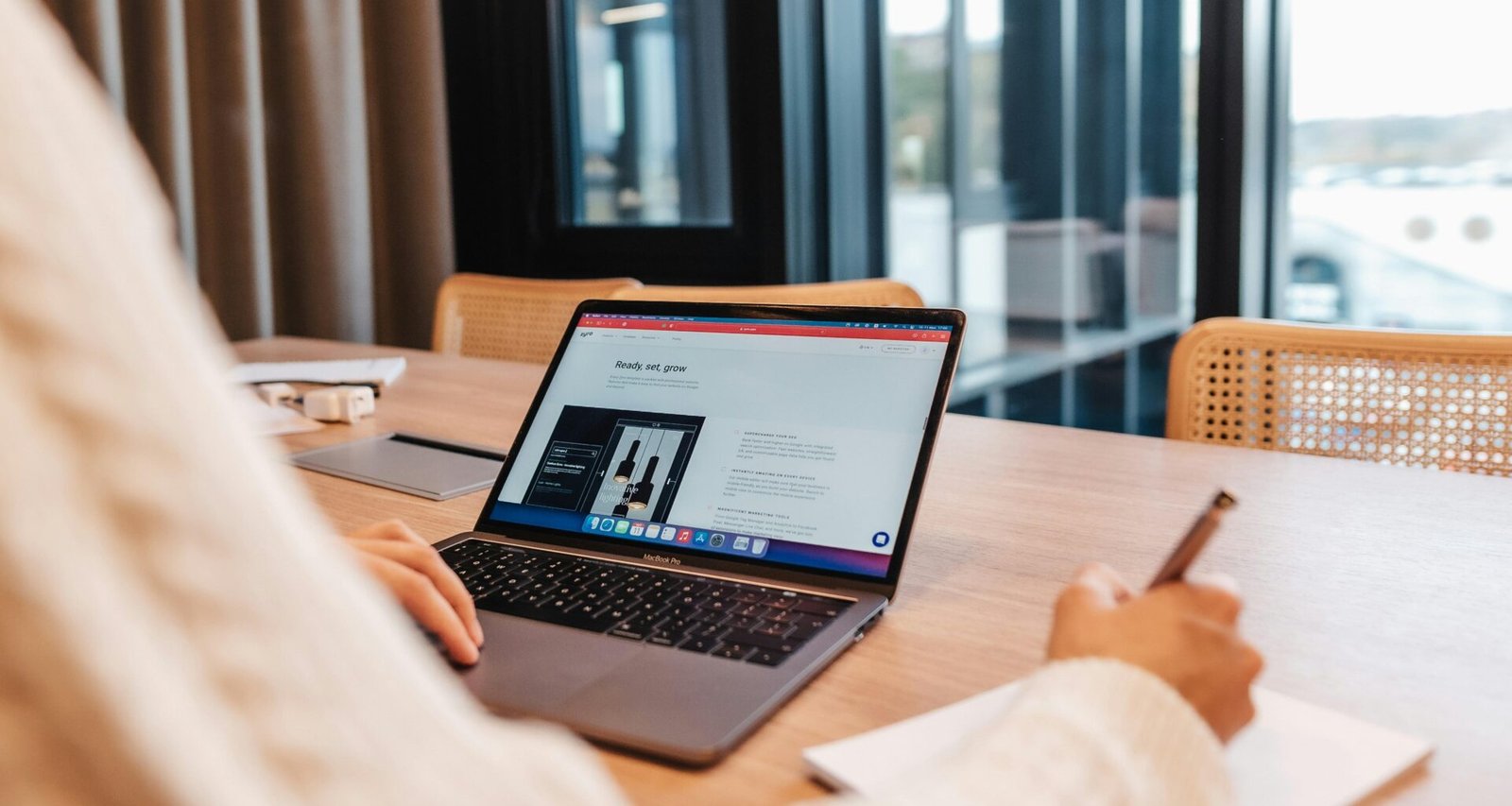 Eine Person sitzt an einem Tisch und arbeitet konzentriert an einem Laptop – Fokus auf digitale Arbeit und Technik.