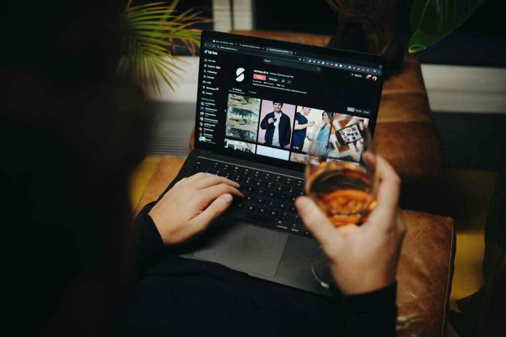 Person sitzt auf einem Sofa und arbeitet am Laptop in entspannter Umgebung – Home-Office-Szene im Alltag.