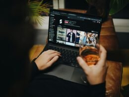 Person sitzt auf einem Sofa und arbeitet am Laptop in entspannter Umgebung – Home-Office-Szene im Alltag.