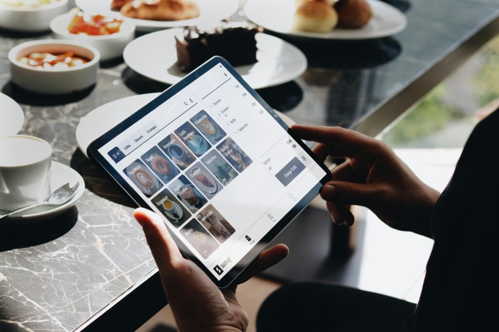 Person sitzt an einem Tisch und bedient ein Tablet, geeignet für Artikel zu digitalem Arbeiten und modernen Technologien.