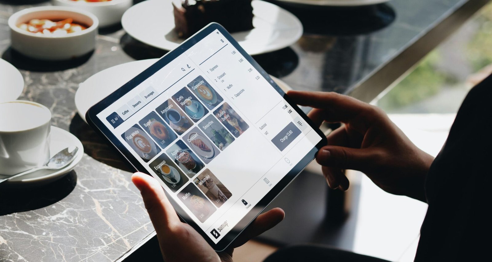 Eine Person sitzt an einem Tisch und arbeitet mit einem Tablet, ideale Darstellung digitaler Arbeitsumgebungen.