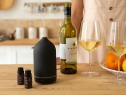 Person steht neben einem Tisch mit mehreren Weinflaschen und Gläsern in entspannter Atmosphäre