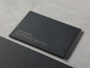 Schwarze Visitenkarte liegt mittig auf hellem Holztisch, minimalistisches Design für Geschäftspräsentationen.